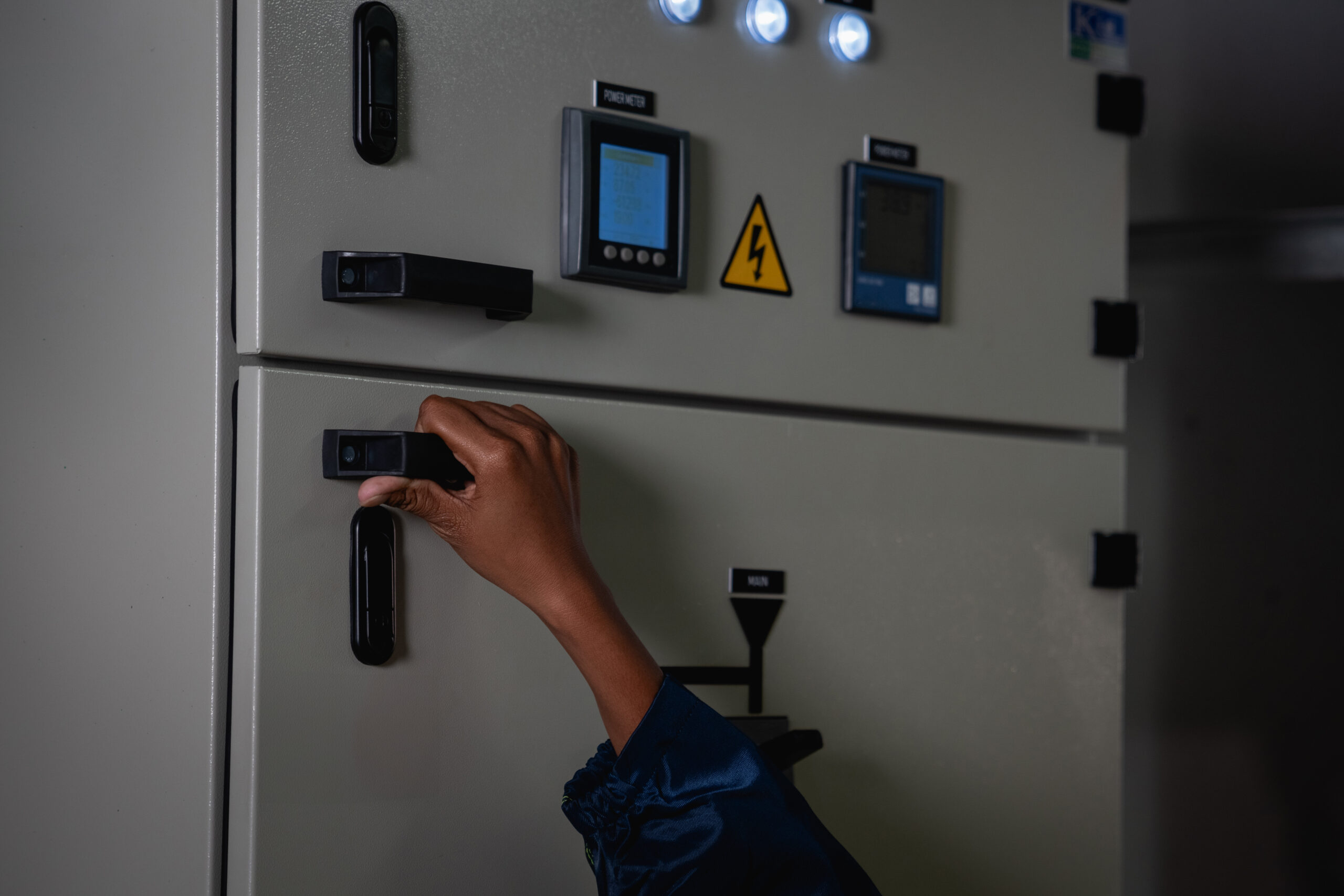 Hand of Technician is touching a switch on a power box